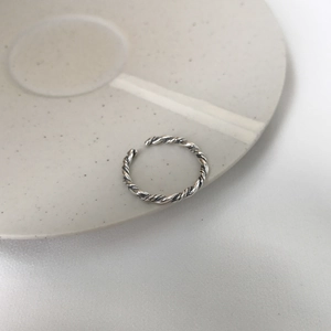 Detail view of S925 sterling silver open ring with vintage twisted rope texture on a plate