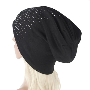 Detail of black knit beanie with shiny silver rhinestones and slouchy fit design
