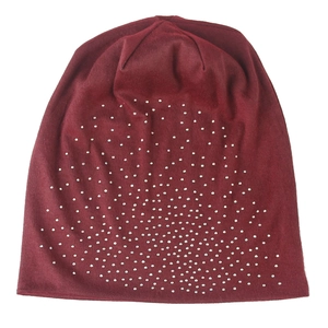 Detail of burgundy knitted beanie featuring sparkling silver rhinestones in a starburst pattern