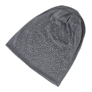 Detailed view of grey knitted beanie with dense silver rhinestones and warm fabric texture