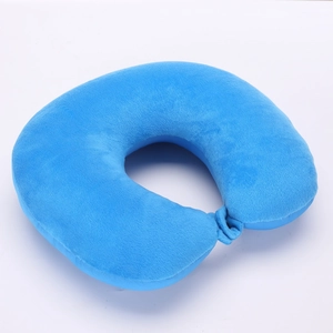 Top view of a bright blue plush U-shaped travel neck pillow on a white background