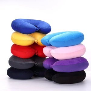 Detailed pile of multi-color plush U-shaped travel neck pillows in various vibrant shades