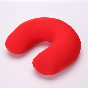 Close-up of bright red U-shaped travel neck pillow with soft plush fabric texture