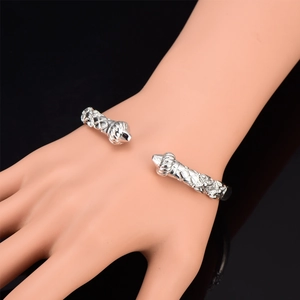 Detail of silver-plated braided open bangle featuring vintage-style engraved ends