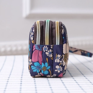 Detailed side view of three-layer floral canvas clutch showing depth and zip structure