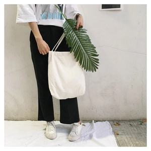 Detail of minimalist white washed cotton linen tote bag with slender dual shoulder straps