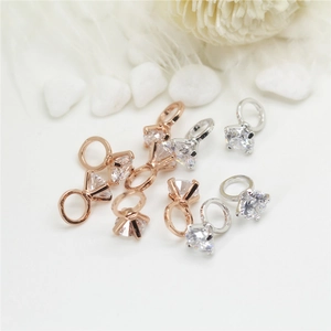 Close-up of rose gold and silver pendants with faceted stones and small ring connectors