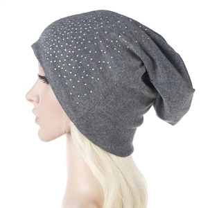 Detail of grey knitted winter hat with shimmering rhinestones on a mannequin head