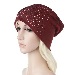Close-up of wine red knit beanie with silver rhinestone wave pattern for autumn