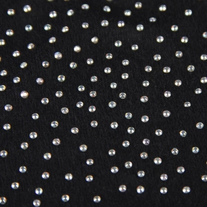 Macro shot of colorful rhinestones on black knitted fabric showing sparkling details