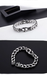 Dettaglio macro di bracciale da uomo vintage in acciaio con incisione gotica e maglie