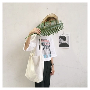 Detailed view of an off-white cotton canvas tote bag paired with a vintage graphic t-shirt