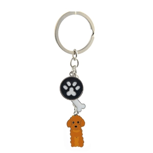 Macro shot of silver metal keyring with paw print, bone charms, and brown poodle pendant