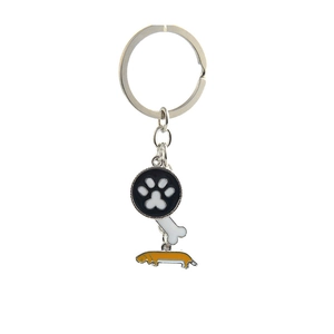 Detail of metal keychain with dog paw, bone, and yellow dachshund enamel charms