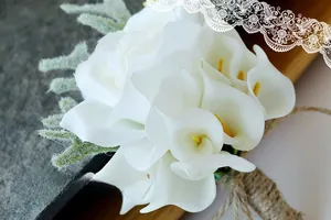 Detail of wedding boutonniere with white calla lily and rustic twine handle decoration