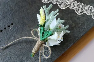 Detail of white calla lily boutonniere with deer antler accent and hemp rope wrap