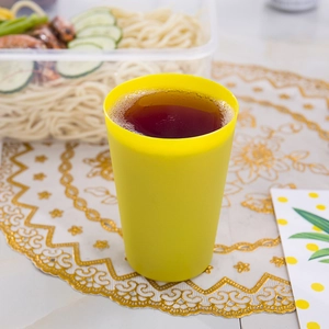 Top view of a durable yellow plastic stackable cup for children focus training on a table