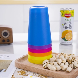 Close-up of colorful stacking cups on a wooden tray for children's focus training