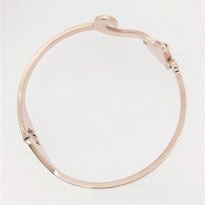 Detail of rose gold open cuff bracelet with elegant wave-shaped curve and polished finish