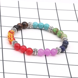 Tiger eye and chakra stone yoga bracelet with silver beads on a white background