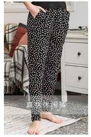 Detailed view of luxury silk harem pants with white polka dot pattern and soft texture