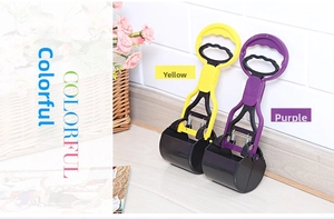 Close-up of portable pet pooper scooper in yellow and purple with spring jaw mechanism