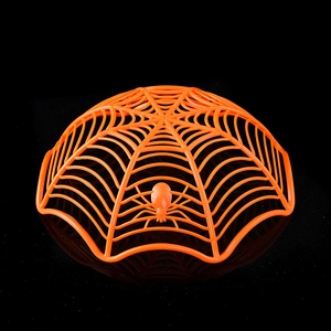 Detail of orange spider web fruit bowl with realistic 3D spider for Halloween decor
