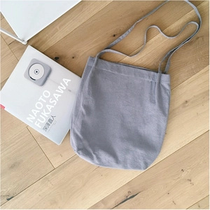 Minimalist grey washed cotton linen tote bag with slim straps on light wooden floor