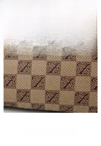 Detailed view of brown PU leather fabric featuring monogram pattern and Z logo texture