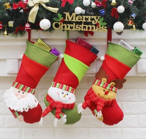 Close-up of three knitted Christmas stockings with Santa, Snowman, and Reindeer dolls