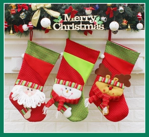 Three hanging Christmas stockings featuring Santa, snowman and reindeer on a festive mantle