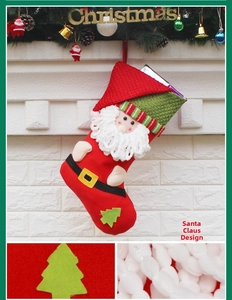 Detail of red plush Christmas stocking featuring a 3D Santa Claus and plaid green cuff