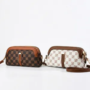 Detail of checkered patterns and gold hardware on small double zipper crossbody bags