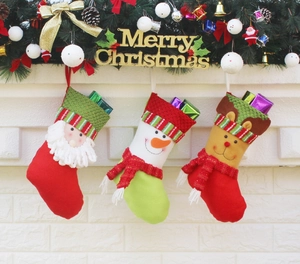 Three Christmas stockings with Santa, Snowman, and Reindeer hanging on a fireplace mantel