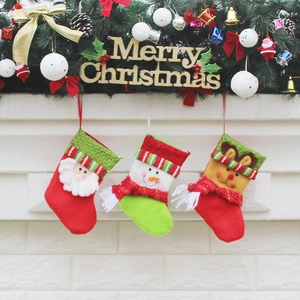 Set of 3 Christmas stockings with Santa, Snowman, and Reindeer hanging on a festive mantel