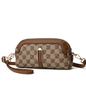 Detailed view of vintage monogram fabric and brown leather trim on the shoulder bag