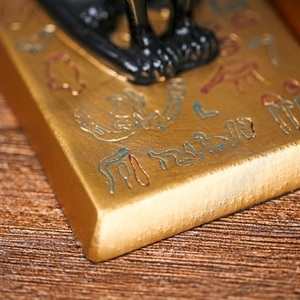 Macro-detail van de Egyptische kattenboekensteun met gouden hiërogliefen en emaille