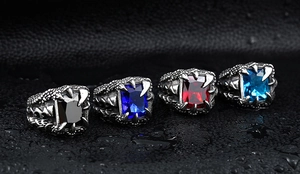 Detailed macro view of four men's dragon claw rings with vibrant zircon stones