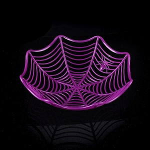 Macro shot of purple spider web candy bowl with plastic spider on black background