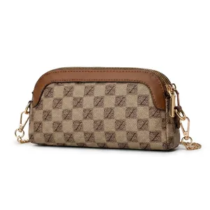 Detail view of the back of a vintage brown monogram crossbody phone bag with gold zippers