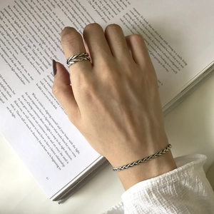 Macro detail of retro S925 sterling silver braided texture ring and bracelet on hand
