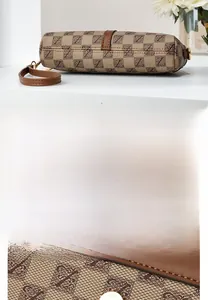 Detail showing the monogram pattern fabric and reinforced brown leather bottom of the bag