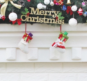 Detail view of Santa and Snowman felt Christmas stockings hanging on a festive mantelpiece