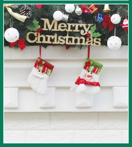 Detail of Christmas wreath with berries and stockings featuring Santa and Snowman