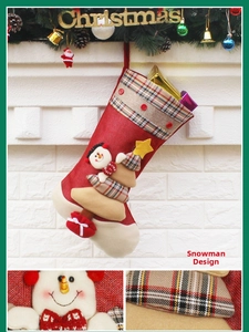 Detail view of snowman embroidery on red linen Christmas stocking with plaid cuff and buttons