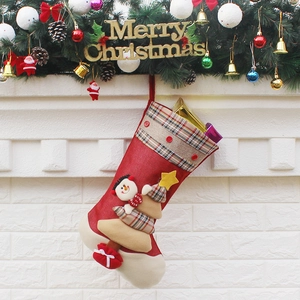Classic red Christmas stocking with snowman decor hanging on a festive fireplace mantel