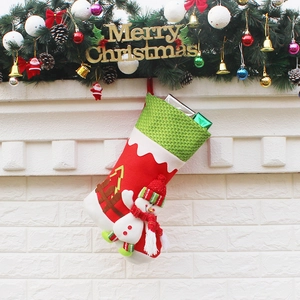 Classic red and green Christmas stocking with 3D snowman hanging on white brick fireplace