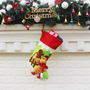 Christmas stocking with 3D reindeer hanging on a white fireplace with festive pine decorations