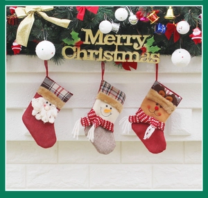 Three festive Christmas stockings with Santa and snowman hanging on a white brick fireplace