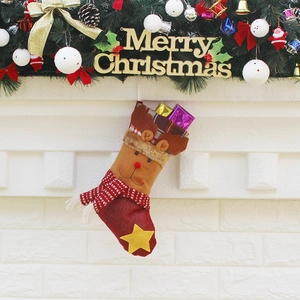 Chaussette de Noël à carreaux avec renne et étoile sur fond de cheminée décorée